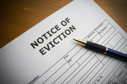 Eviction lawyers in NJ presenting notice of eviction form with a blue and black pen